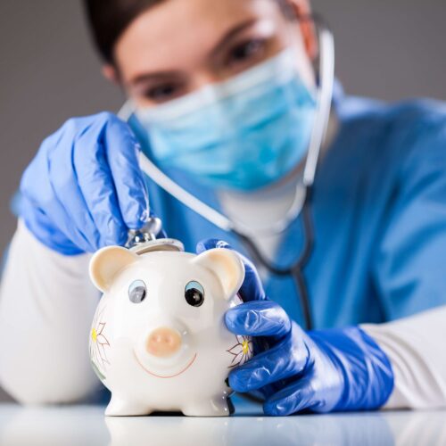 Doctor inspecting piggy bank with stethoscope