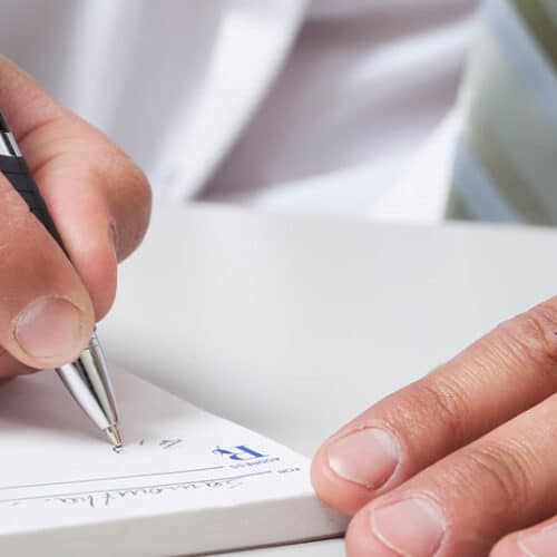 doctor writing prescription for financial wellness - financial guide for physicians and doctors