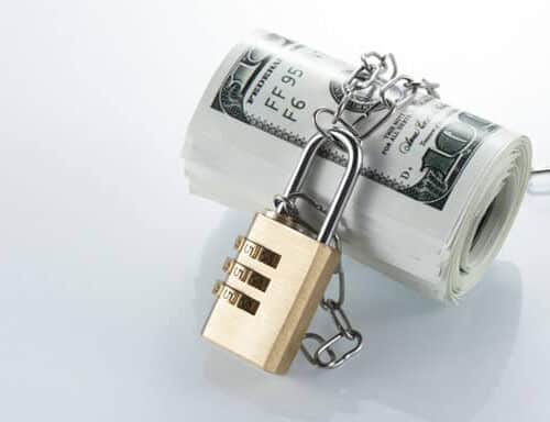 Roll of cash (USD) with a chain and combination lock around it.