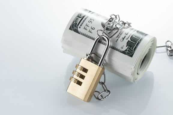 Roll of cash (USD) with a chain and combination lock around it.