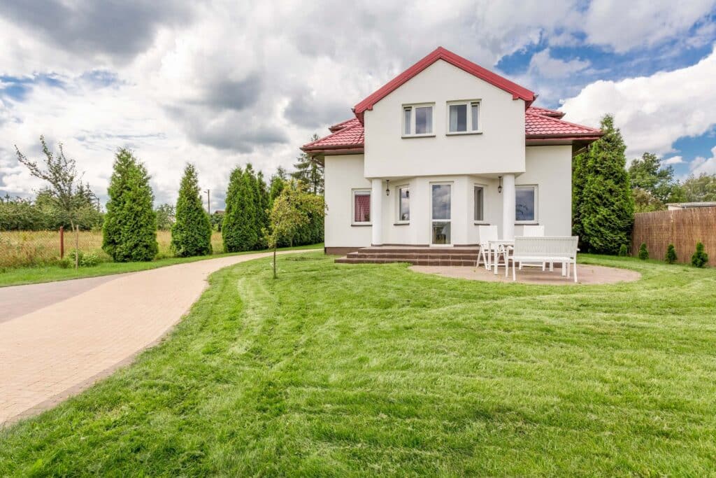 Large White House with huge green lawn and trees