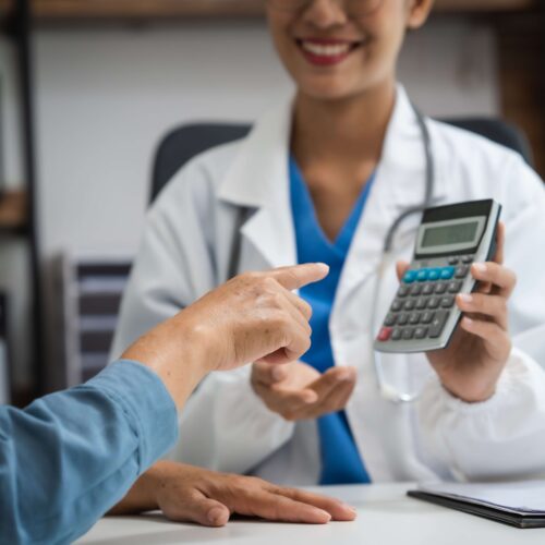 Young Chinese woman doctor in white coat with holding up a calculator and smiling