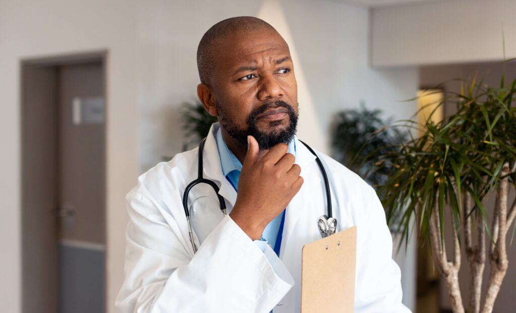 Thoughtful bearded doctor with a clipboard 