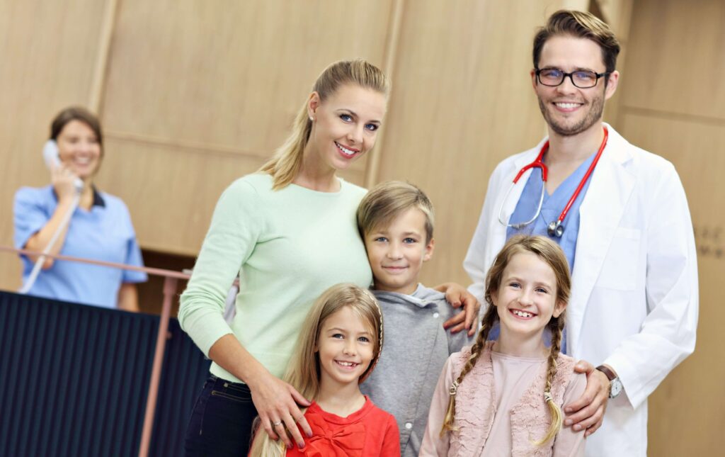 Doctor and his family (wife and three children) smiling for camera 