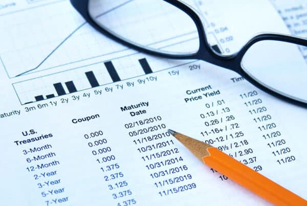 image showing us treasury bonds with a pencil and glasses